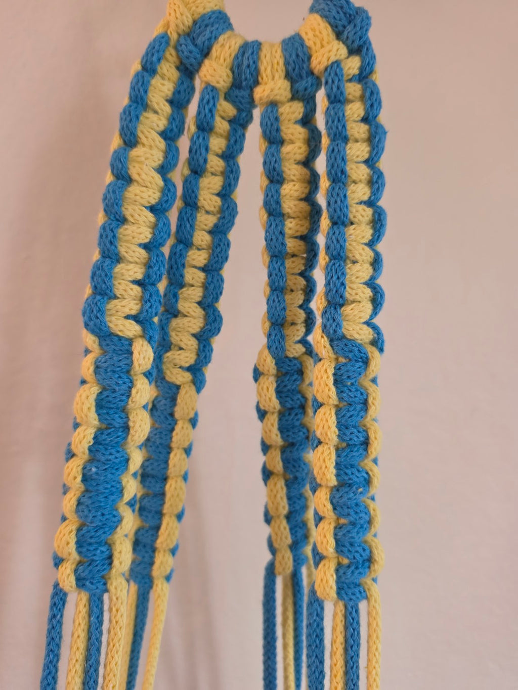 Close-up of blue and yellow hand-knotted macrame detailing