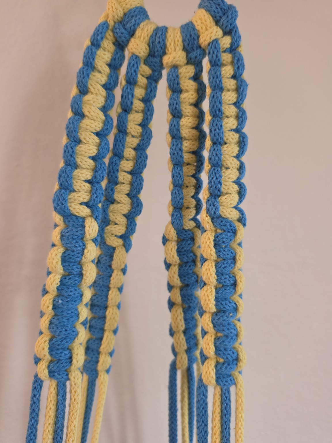 Close-up of blue and yellow hand-knotted macrame detailing